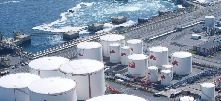 A cylindrical storage silo at an industrial factory with AVIA branding. This image showcases the power station infrastructure and industrial pipes.